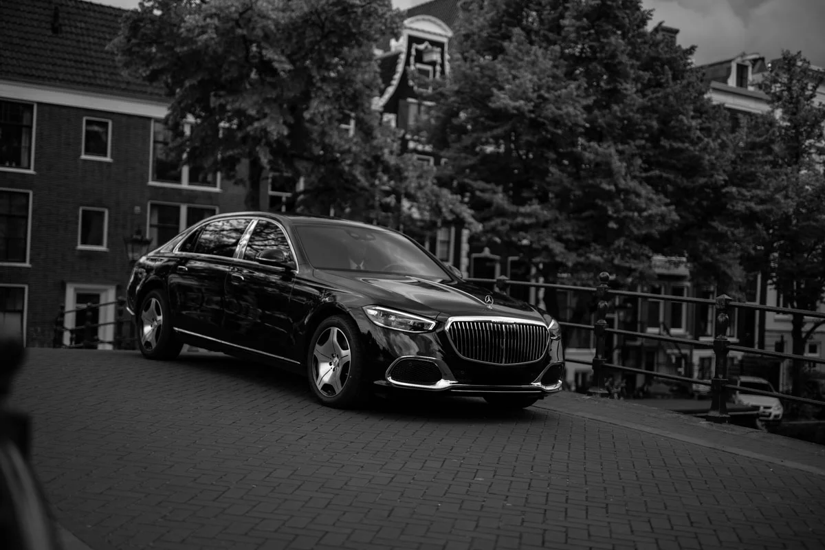 Chauffeur Service in Hoofddorp on top of a bridge with a man walking in front of the car.